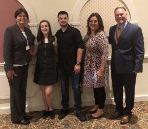 A group photo of two students and three adult administrators