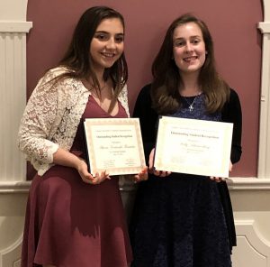 Two high school girls hold certificates