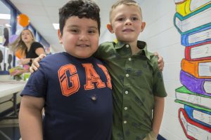 Two boys with their arms around eachother's shoulders