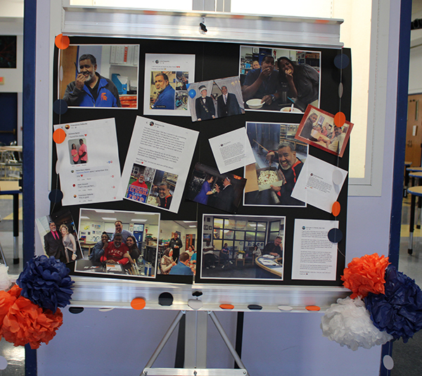 A large bulletin board with photos  on it sits on an easel.