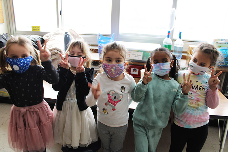 Five little girls wearing tutus, tie dye and all giving peace signs.