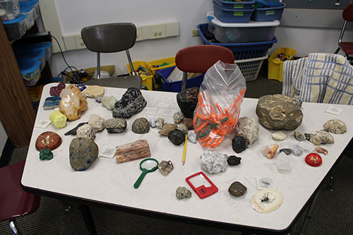 A table is filled with different rocks.