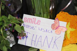 A close up of a card that has a pink butterly on it and says Smile Nurse Lysack Thank