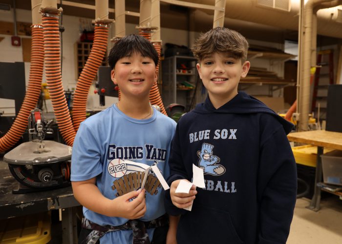 Two students pose for a photo in a shop class