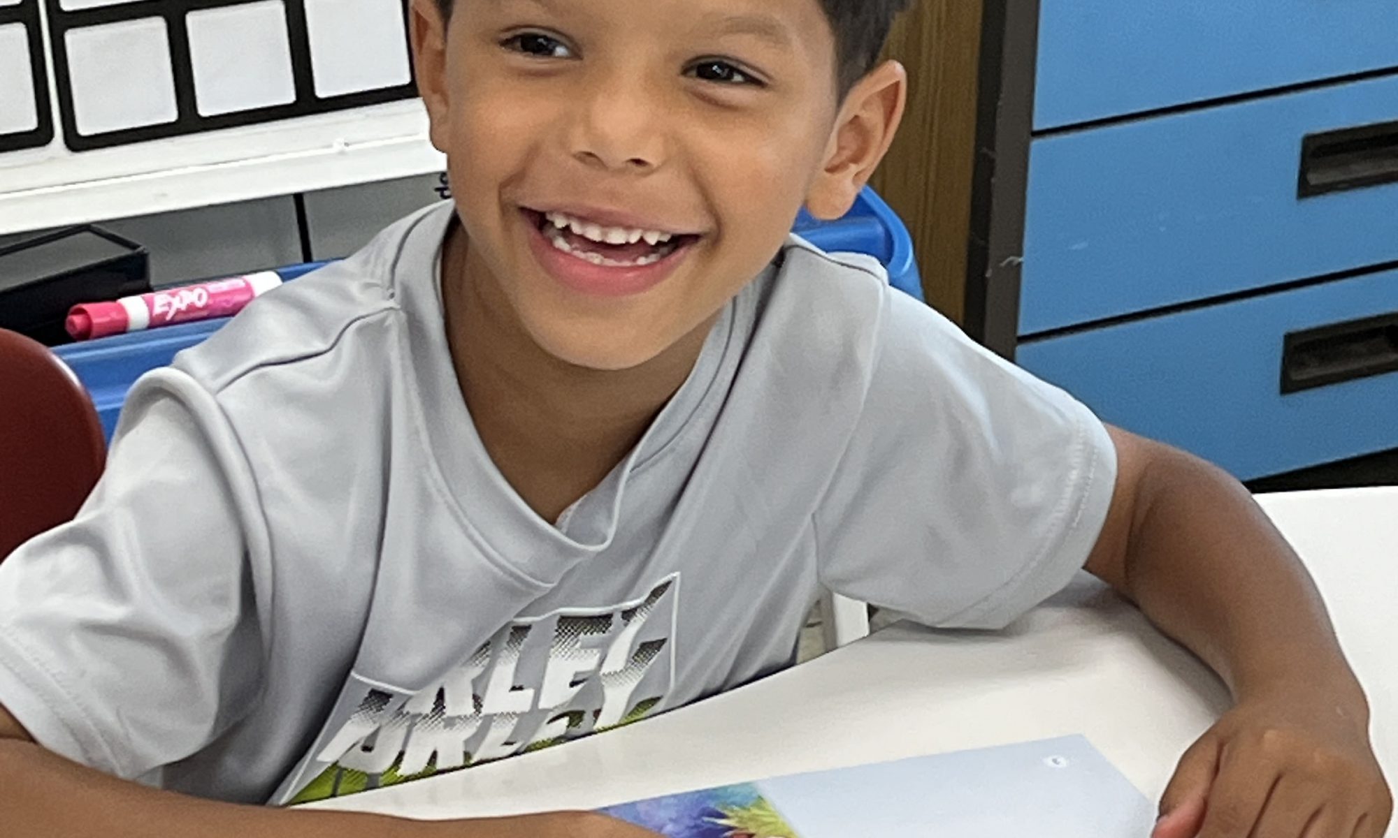 A student smiles as he reads a book