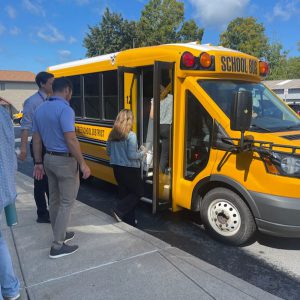 Adults enter a school bus