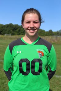 A soccer player in a green 00 jersey smiles.