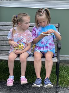 Two students eat on a bunch