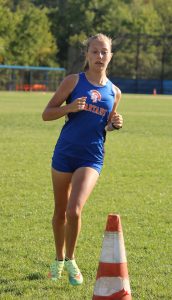 Taylor Vogt runs around a cone.