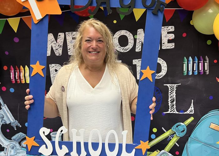 A person holds a first day of school frame