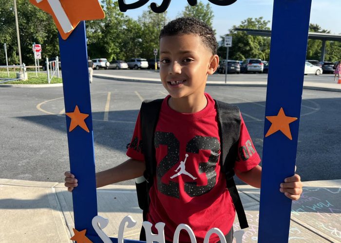 A student holds a first day of school frame