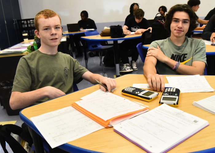 Students wearing green pose for a photo