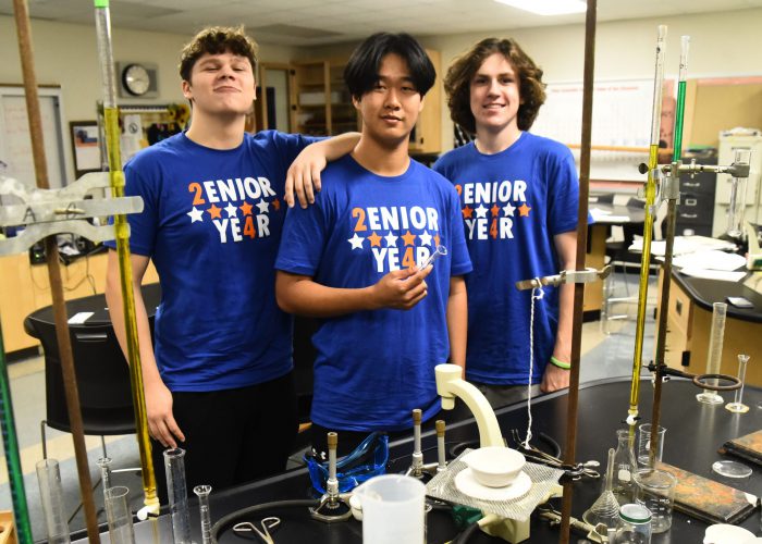 Students wearing blue pose for a photo