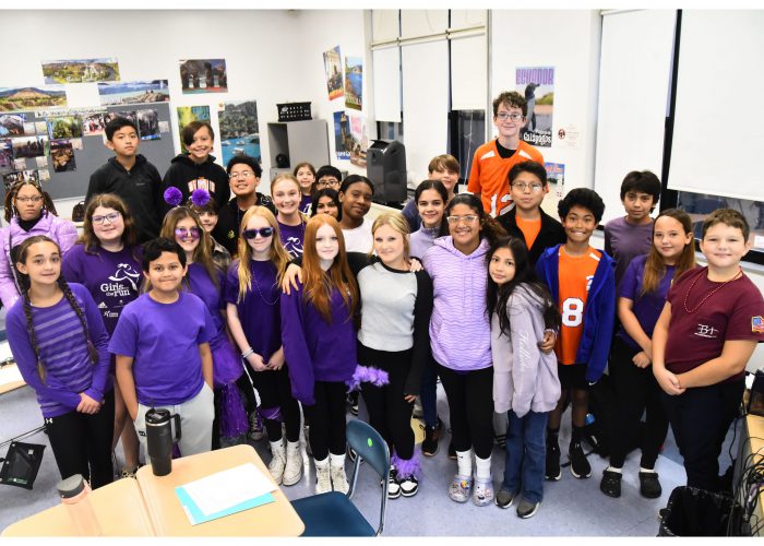 Students wearing purple pose for a photo