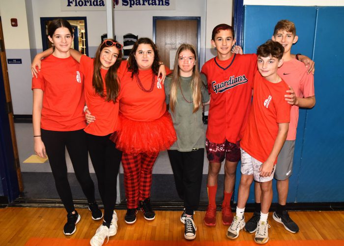 Students wearing red pose for a photo