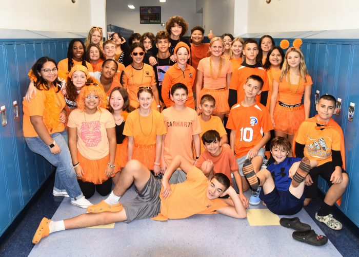 Students wearing orange pose for a photo