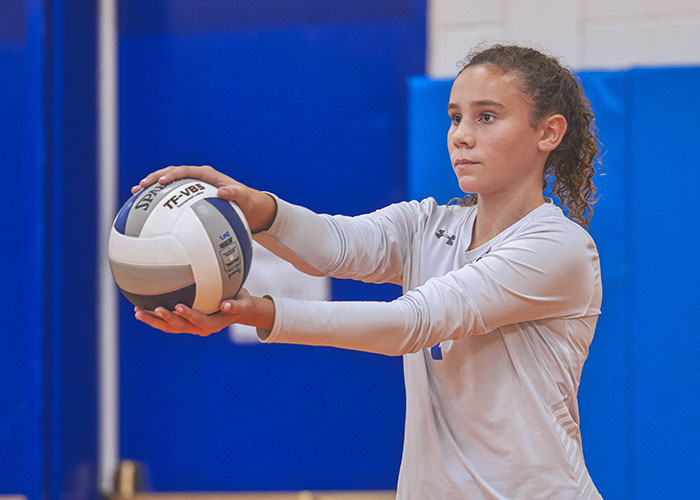 a volleyball player prepares to serve the ball.