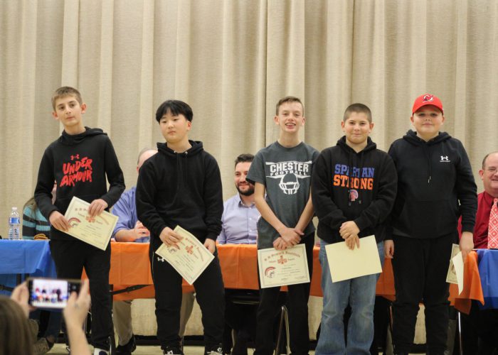 Student athletes pose on stage for a photo