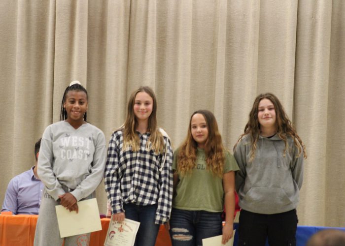 Student athletes pose on stage for a photo