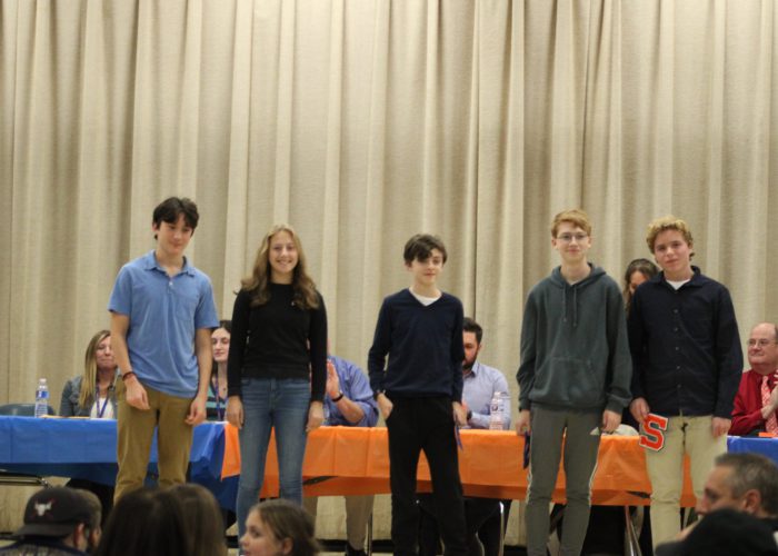 Student athletes pose on stage for a photo