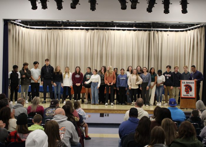 Student athletes pose on stage for a photo