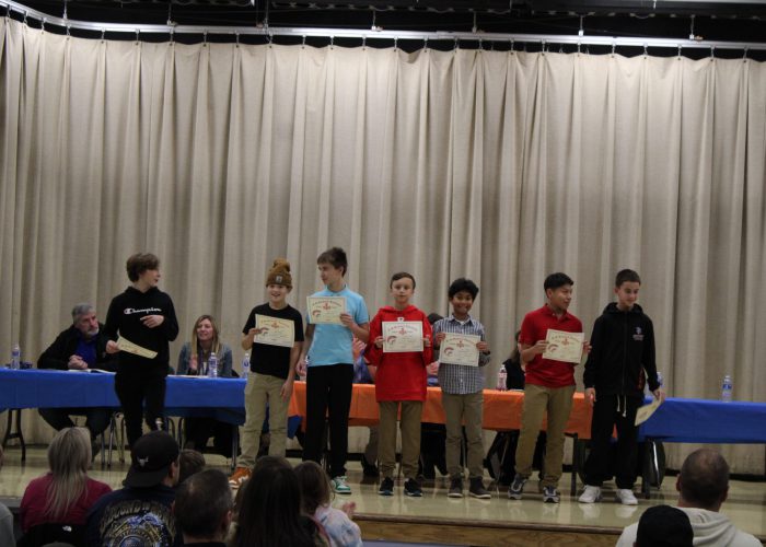 Student athletes pose on stage for a photo