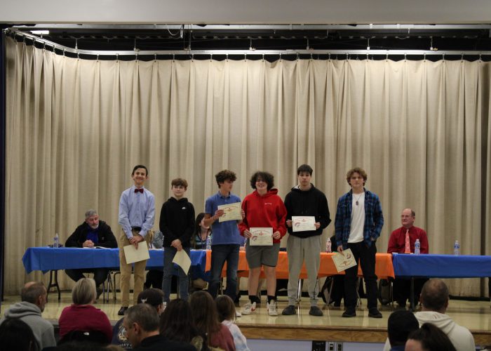 Student athletes pose on stage for a photo