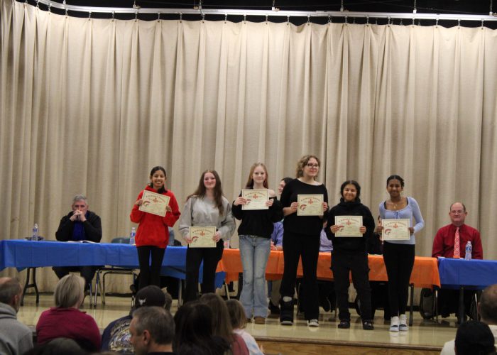 Student athletes pose on stage for a photo