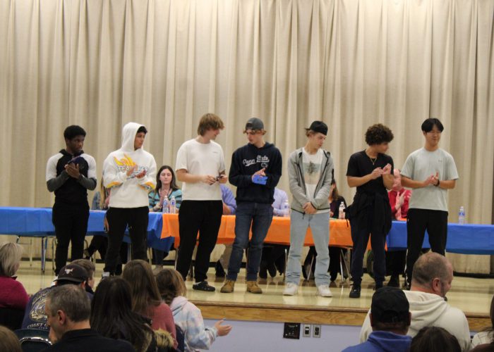 Student athletes pose on stage for a photo