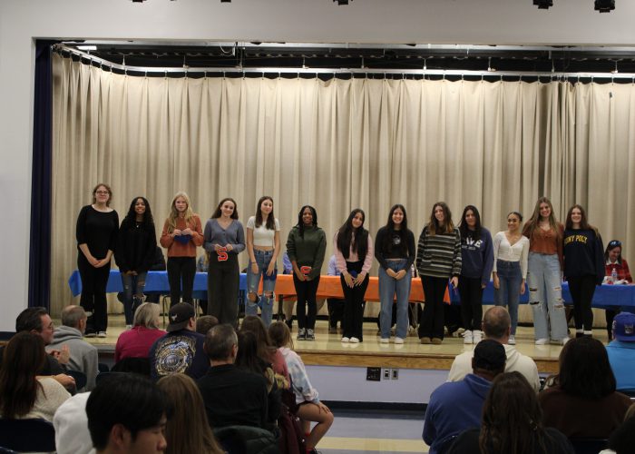 Student athletes pose on stage for a photo