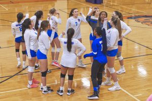 Volleyball team cheering in huddle