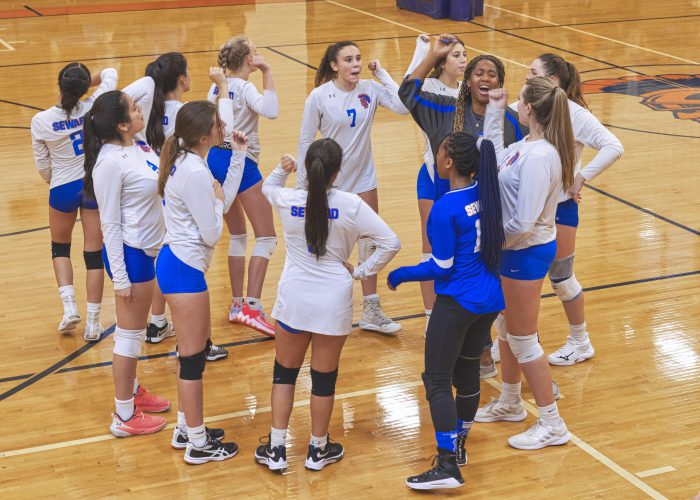 Volleyball team cheering in huddle