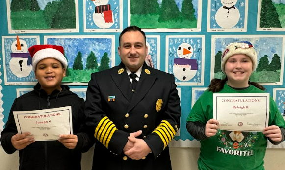 Chief Andryshak and student essay winners pose for photo