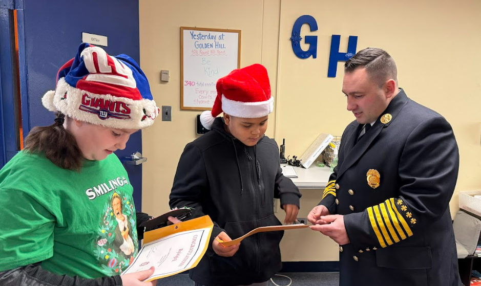 Chief Andryshak giving certificates to student essay winners