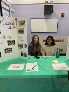 Students pose in front of poster board