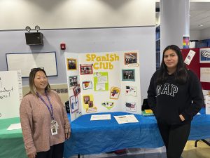 Teacher and student pose in front of poster board