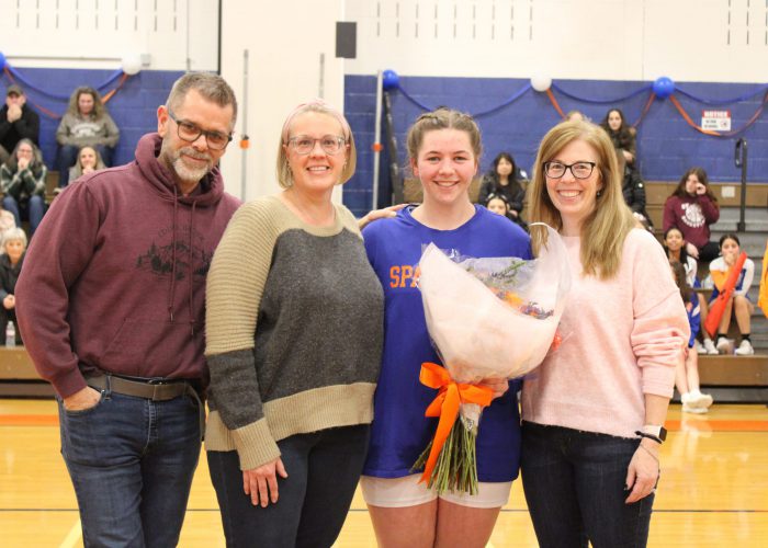 Family poses for photo in gym