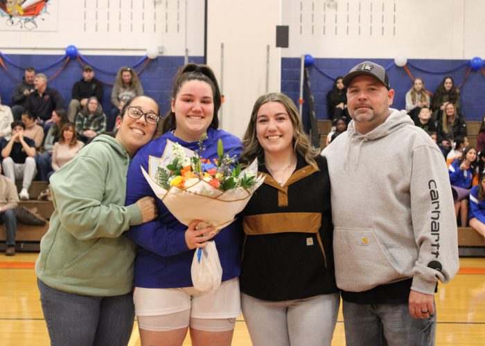 Family poses for photo in gym