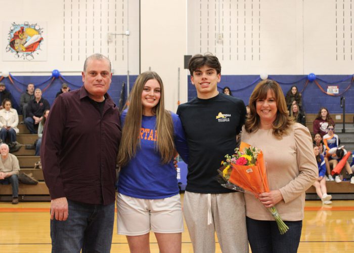 Family poses for photo in gym