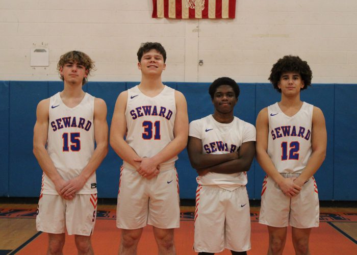 Basketball players pose for photo in white uniforms