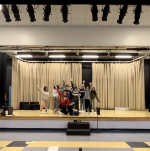 Drama students on stage posing for a photo