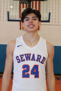 Joe Staszeski stands in the gym in his basketball jersey