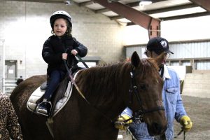 Pre-K student rides horse at Winslow field trip