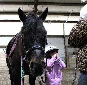 Pre-K student learns about how horses see from volunteer at Winslow field trip