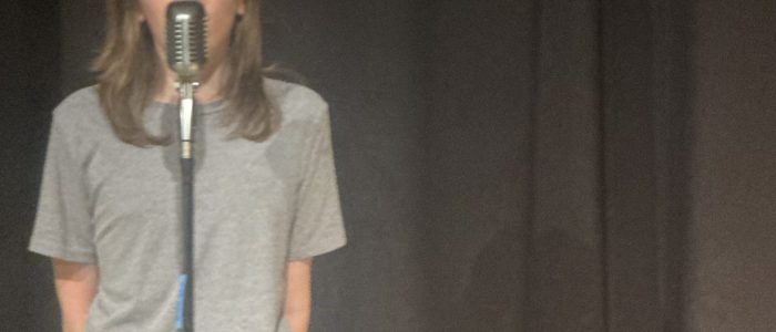Student on stage performing at coffeehouse concert