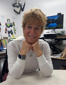 Teacher poses with hands under chin