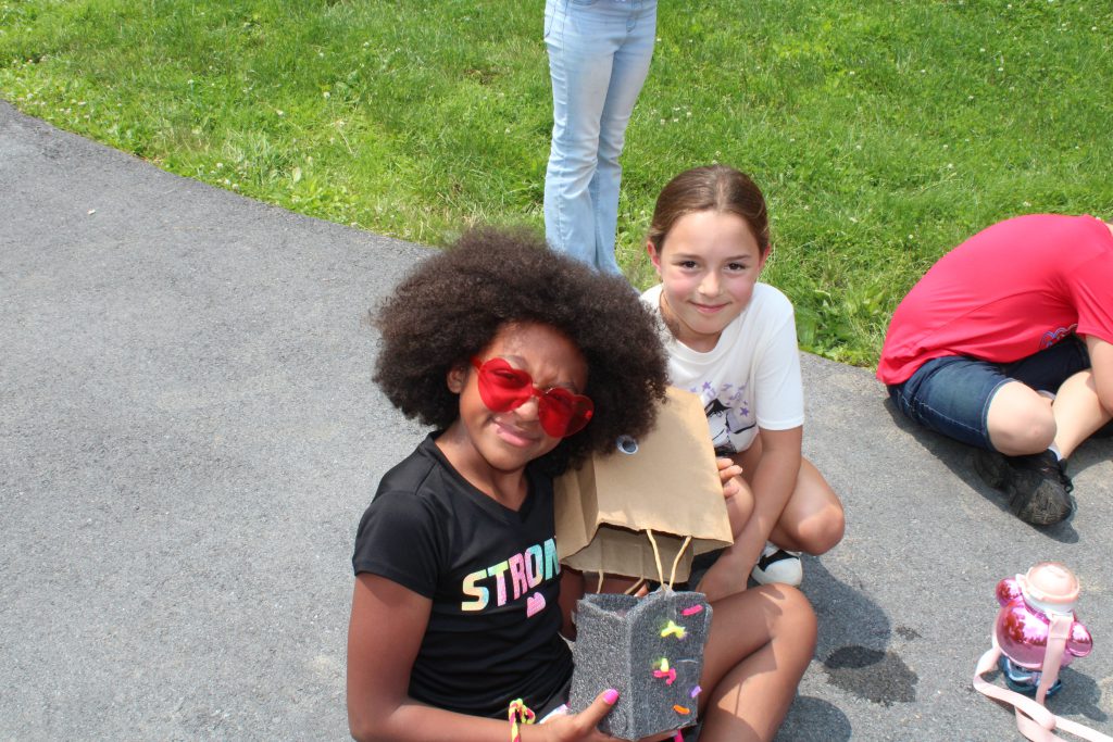 Two students showing egg drop contraption